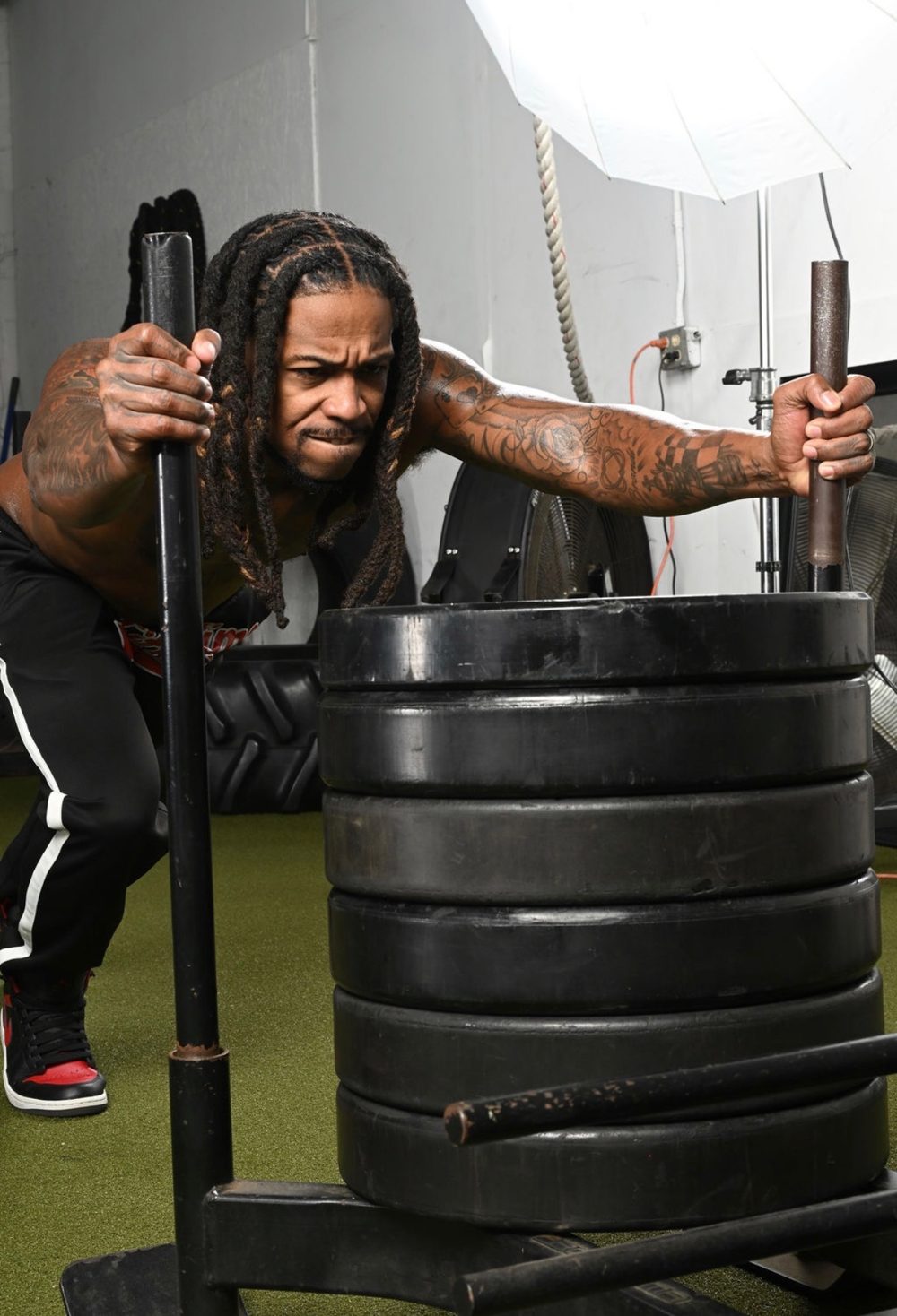 Coach Prime pushing a weighted sled during a strength and conditioning session